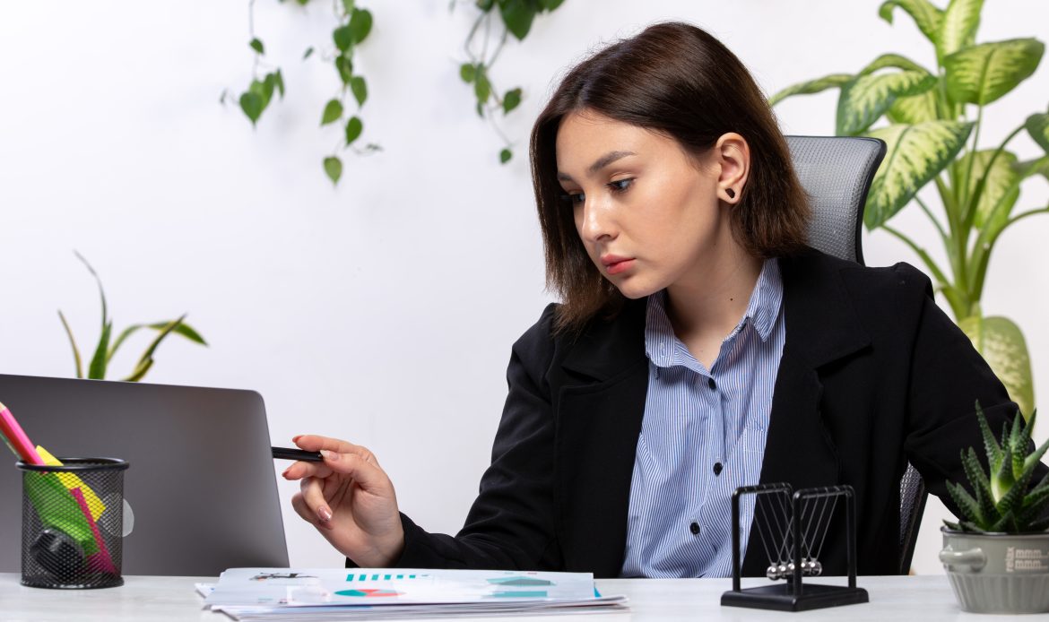 Wedding Investment Planner – Woman planning wedding savings budget using a laptop and financial documents.