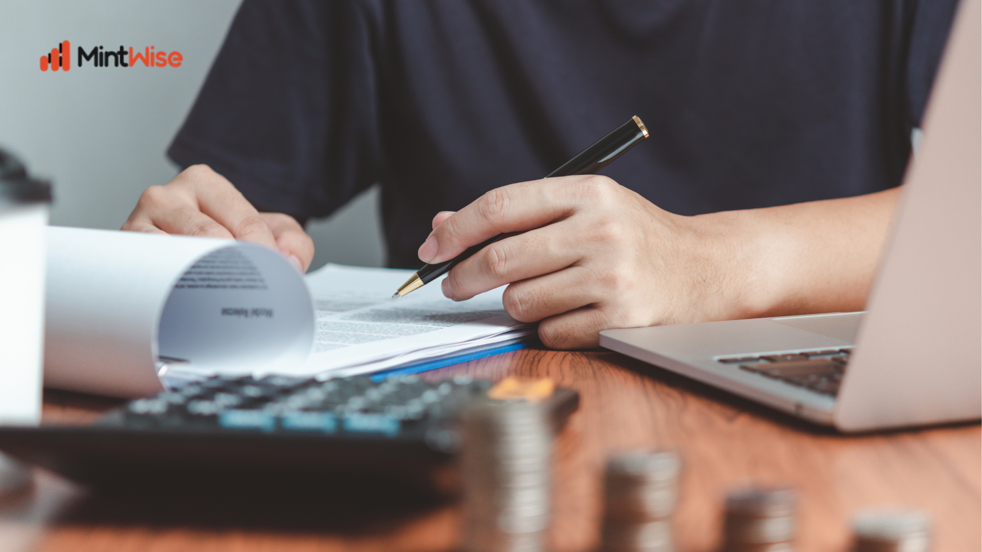 Investor reviewing financial documents and taking notes beside a laptop and calculator for mutual fund investment planning.