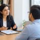 Wealth management consultant discussing financial planning and investment strategies with a couple in a professional office.